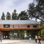 Exterior view of the Bush project, showcasing a modern architectural design with a sleek facade and large windows. The building is surrounded by landscaped greenery, emphasizing its integration with the natural environment. The design features clean lines and a contemporary aesthetic, reflecting innovative architectural principles recognized by the 2022 Honor Awards.