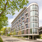 Exterior view of a modern apartment featuring an open living area with large windows, contemporary furniture, and stylish decor.